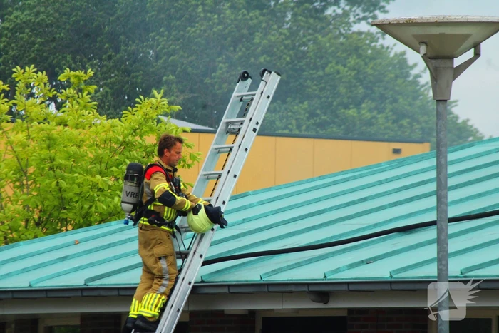 Rook uit dak van schoolgebouw