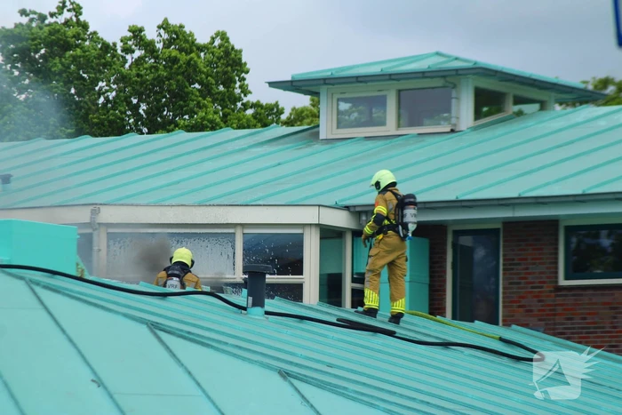 Rook uit dak van schoolgebouw