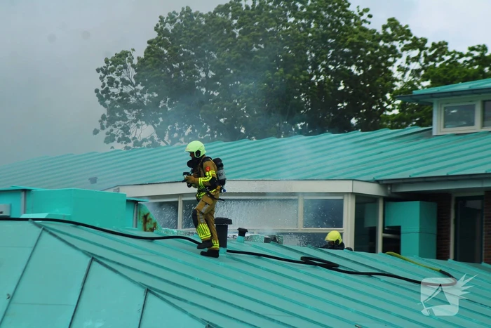 Rook uit dak van schoolgebouw