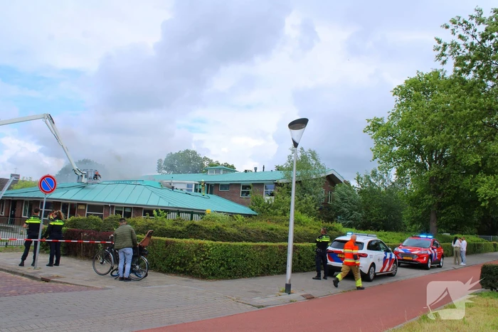 Rook uit dak van schoolgebouw