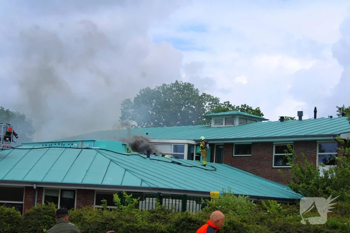 Rook uit dak van schoolgebouw