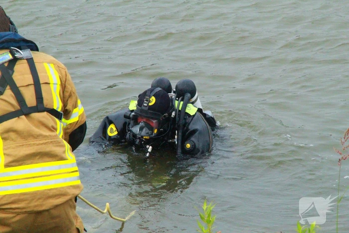 Duikers zoeken naar auto in rivier