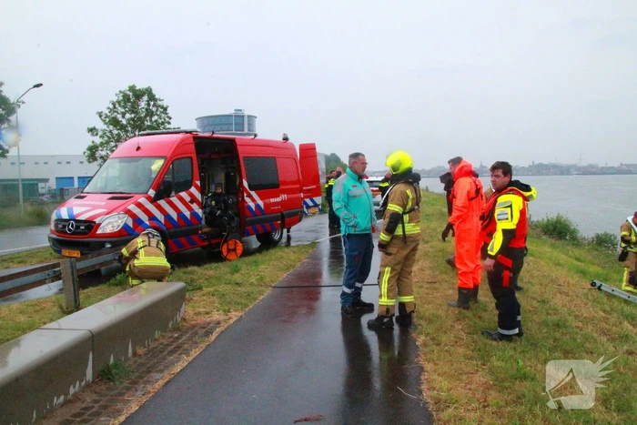 Duikers zoeken naar auto in rivier