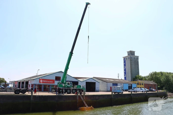 Te water geraakte werkbus door kraan uit water gehaalt