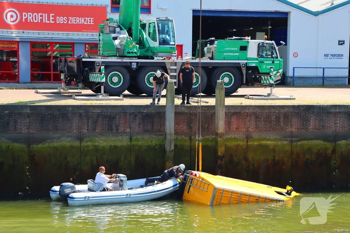 Te water geraakte werkbus door kraan uit water gehaalt