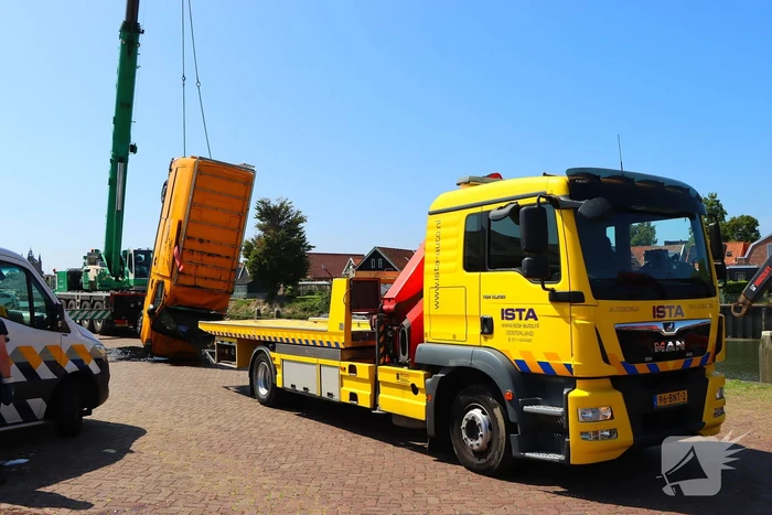 Te water geraakte werkbus door kraan uit water gehaalt