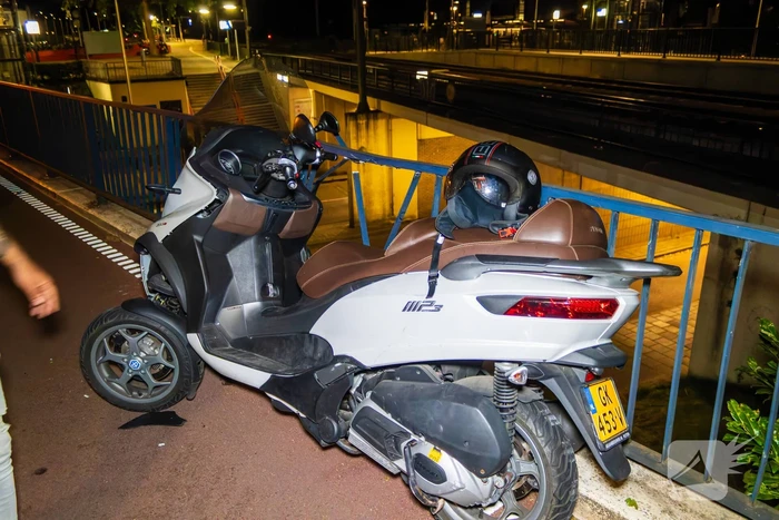 Eenzijdig ongeval met driewielige motorscooter op fietsbrug