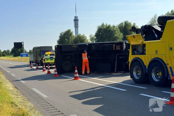 Vrachtwagen kantelt na slip