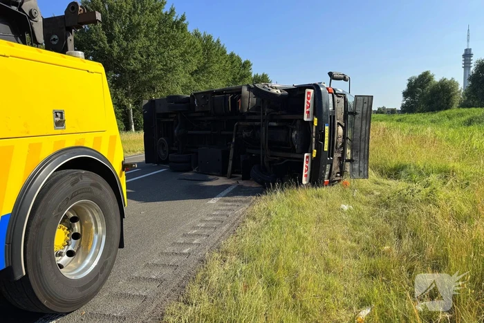Vrachtwagen kantelt na slip