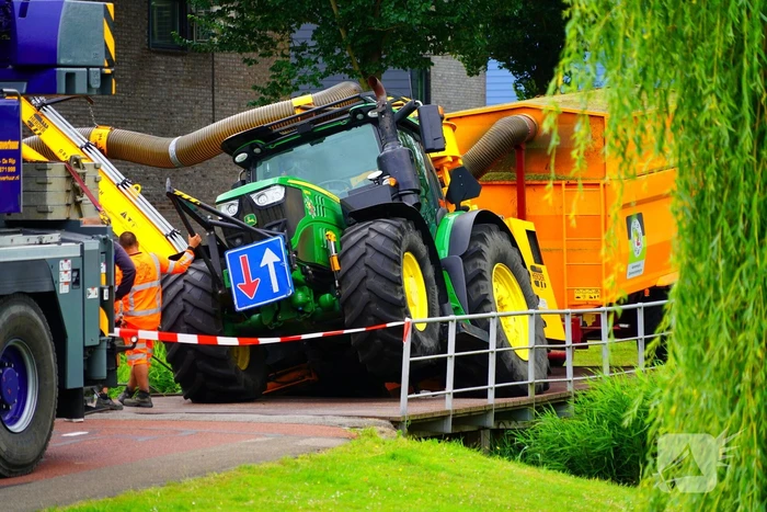 Tractor zakt door brug tijdens werk