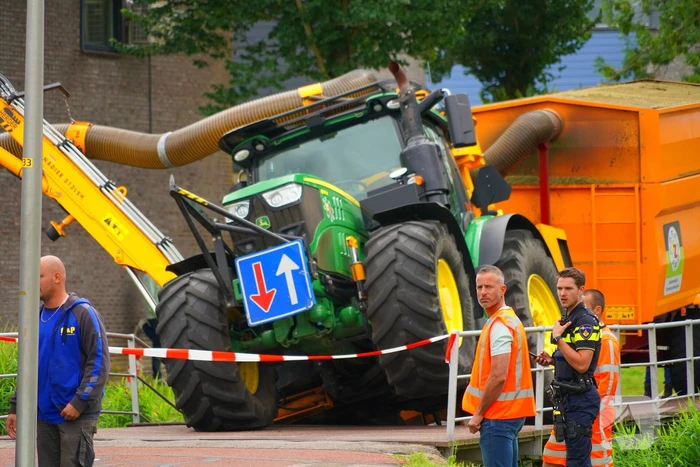 Tractor zakt door brug tijdens werk