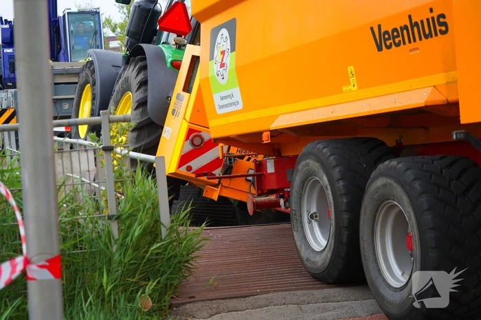 Tractor zakt door brug tijdens werk