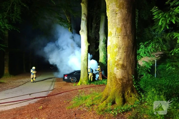 Brandweer blust auto van  250000 00 op parkeerplaats die vlam vat