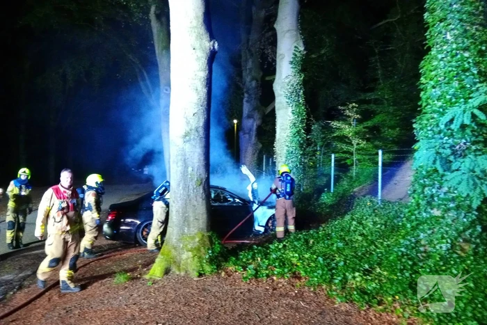 Brandweer blust auto van  250000 00 op parkeerplaats die vlam vat