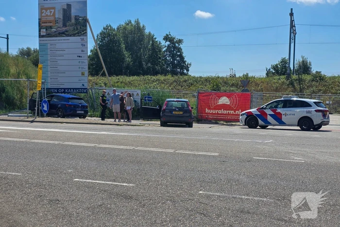 Automobilist ramt hekwerk bij bouwplaats