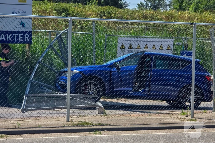 Automobilist ramt hekwerk bij bouwplaats