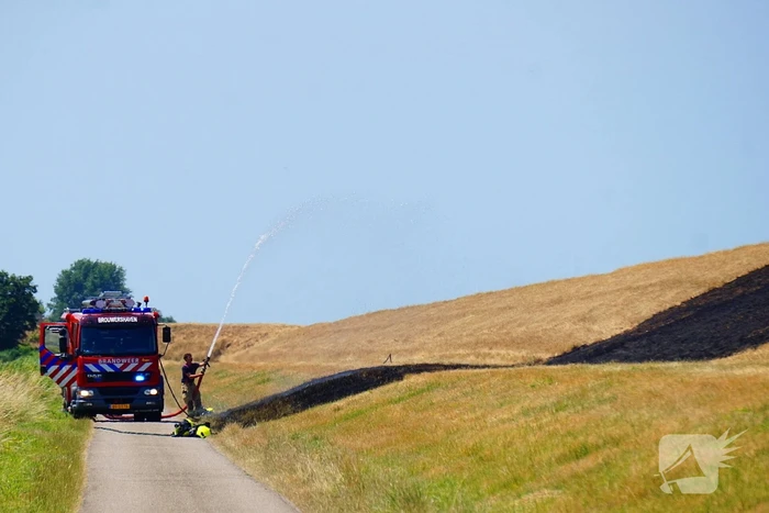 Brandweer blust brand langs dijk