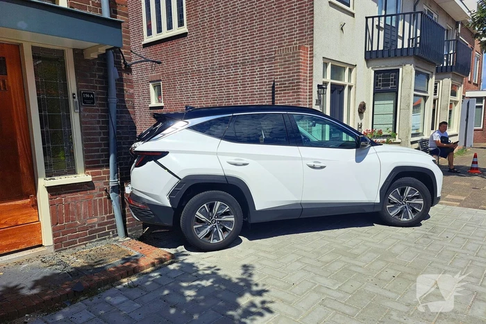 Auto rijdt achteruit tegen woning
