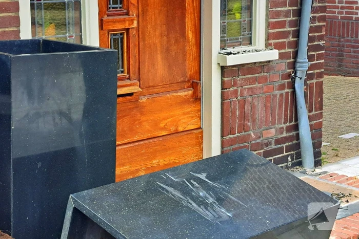 Auto rijdt achteruit tegen woning
