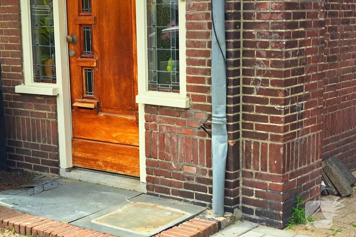 Auto rijdt achteruit tegen woning