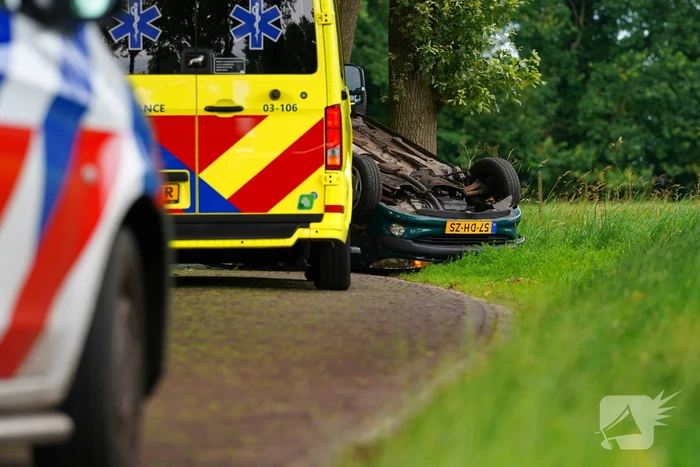 Auto over de kop na botsing