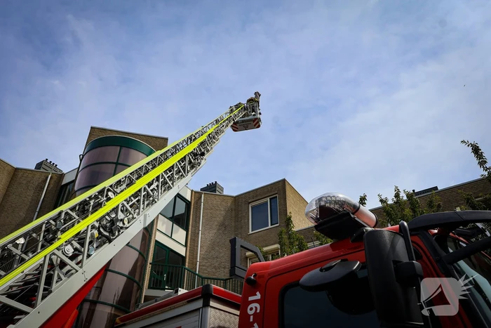 Los gewaaide parasol belandt op dak appartementencomplex