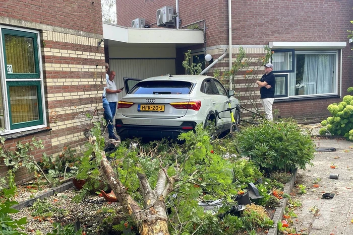Voertuig ramt boom en huis