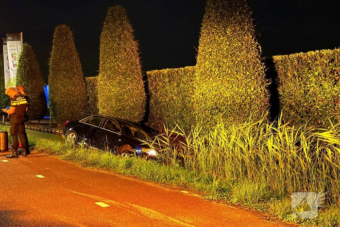 Auto mist bocht en raakt te water
