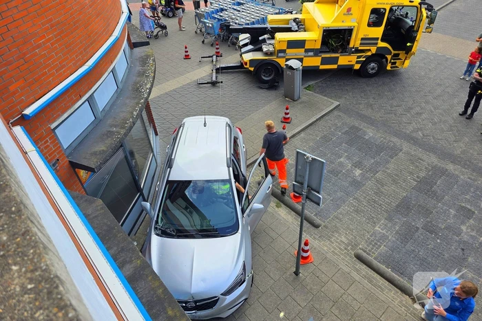 Auto botst tegen winkelpui