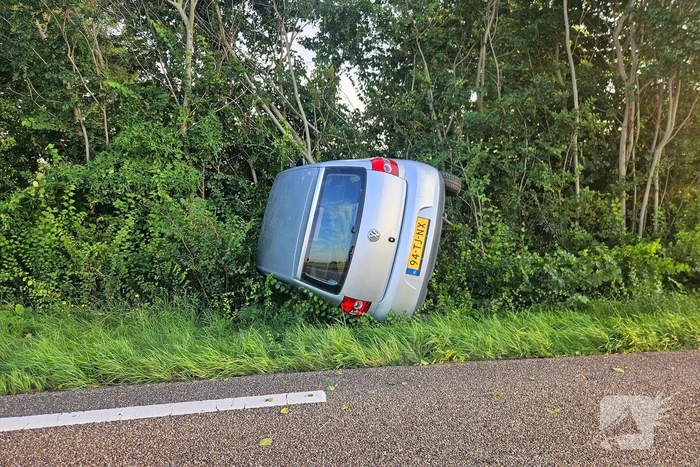Auto kantelt in bosschages