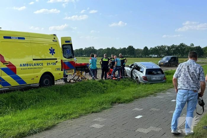 Auto raakt boom en belandt in sloot