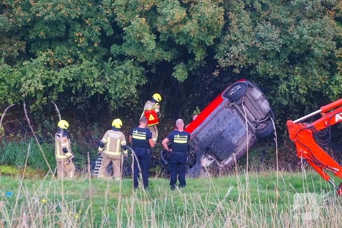Auto rijdt van dijk af en slaat voorover