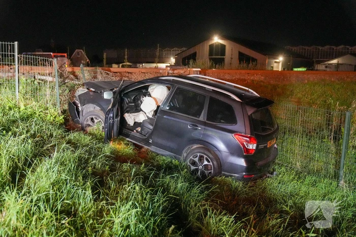 Auto vliegt uit de bocht en knalt tegen hek bij spoorwegovergang