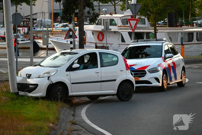 Auto crasht op rotonde en raakt paal