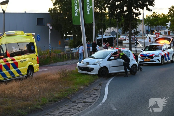 Auto crasht op rotonde en raakt paal