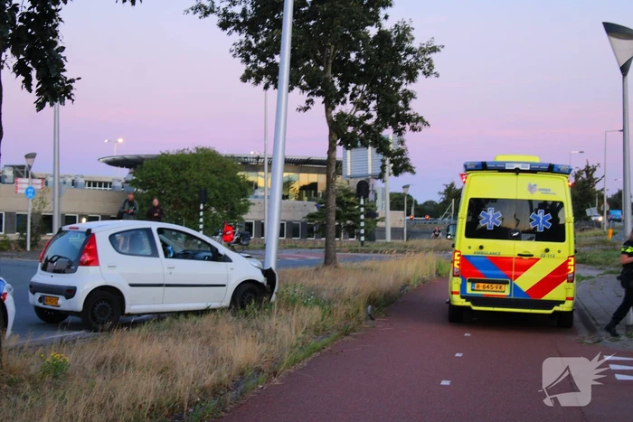 Auto crasht op rotonde en raakt paal