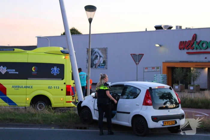 Auto crasht op rotonde en raakt paal