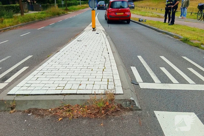 Personenauto botst tegen vluchtheuvel en krijgt lekke band