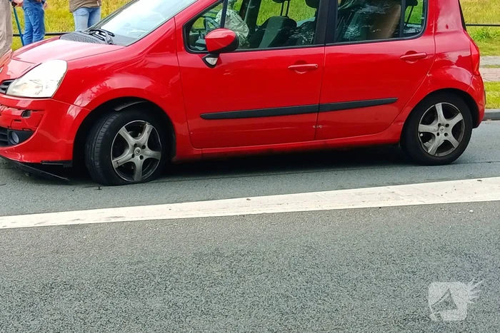 Personenauto botst tegen vluchtheuvel en krijgt lekke band