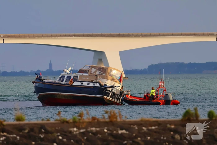 Boot loopt vast op dam, bergingsbedrijf schiet te hulp