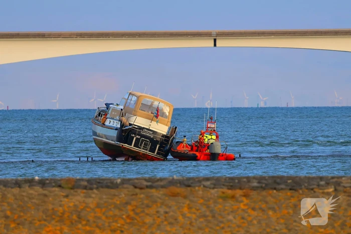 Boot loopt vast op dam, bergingsbedrijf schiet te hulp