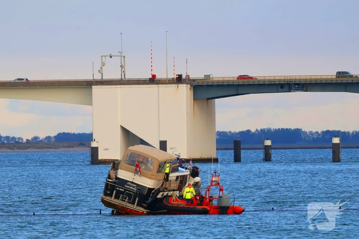 Boot loopt vast op dam, bergingsbedrijf schiet te hulp