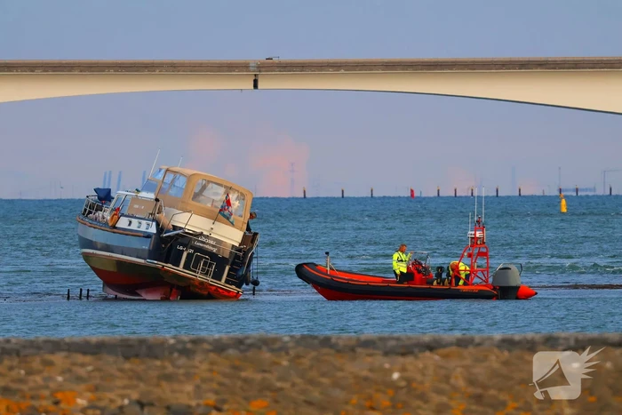 Boot loopt vast op dam, bergingsbedrijf schiet te hulp