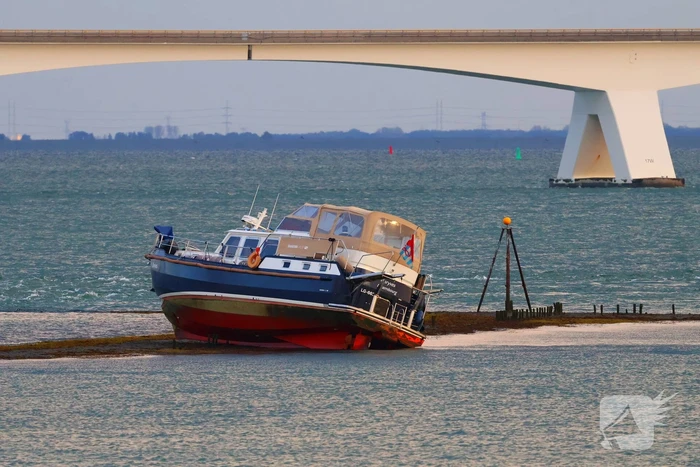 Boot loopt vast op dam, bergingsbedrijf schiet te hulp