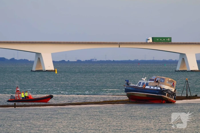 Boot loopt vast op dam, bergingsbedrijf schiet te hulp
