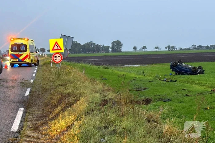 Auto belandt op dak in weiland