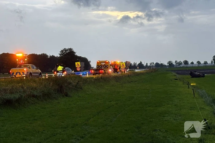 Auto belandt op dak in weiland