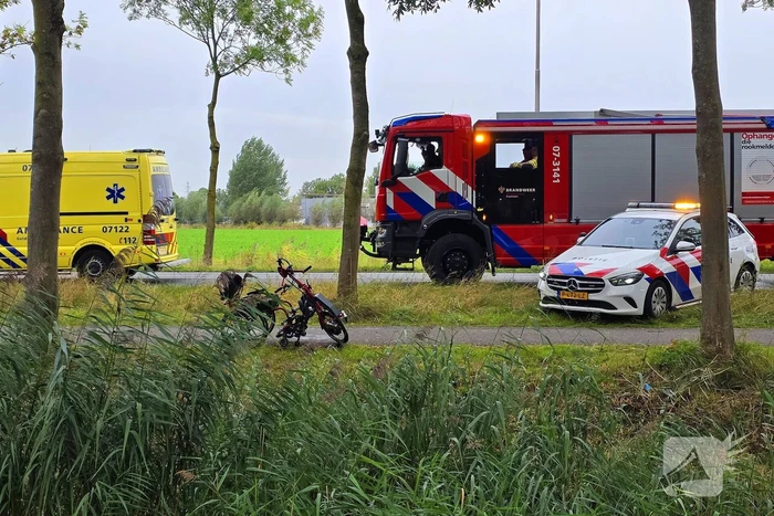 persoon op driewielfiets in water beland