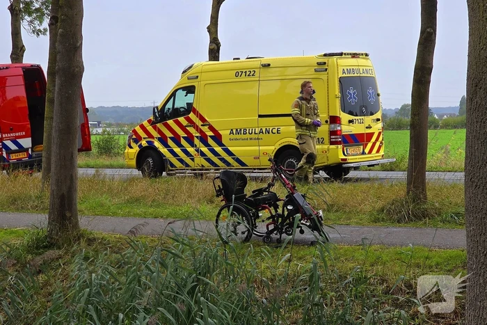 persoon op driewielfiets in water beland