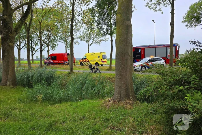persoon op driewielfiets in water beland